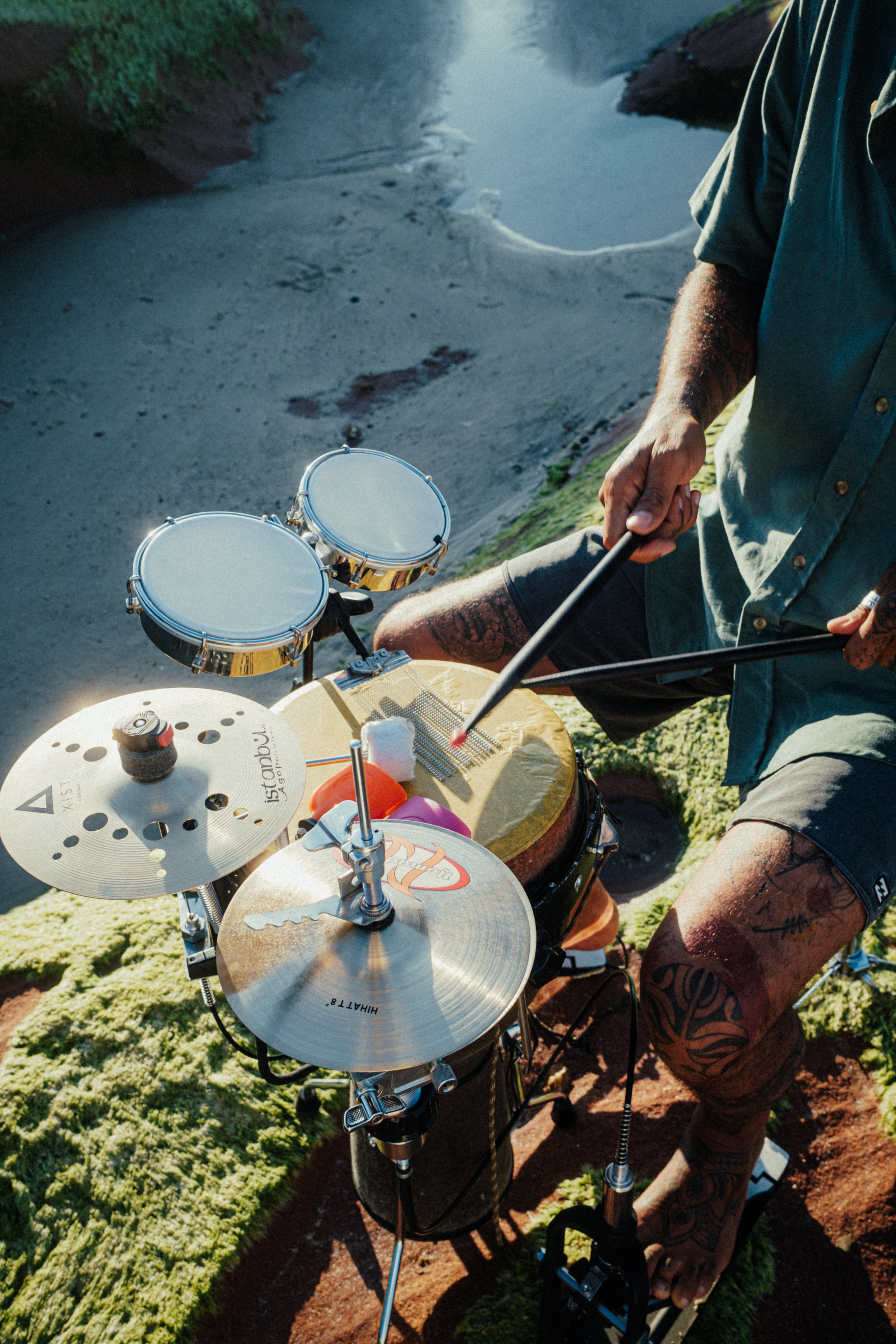 Person playing a drum set outdoors at the beach  @ Roselle Knaus
