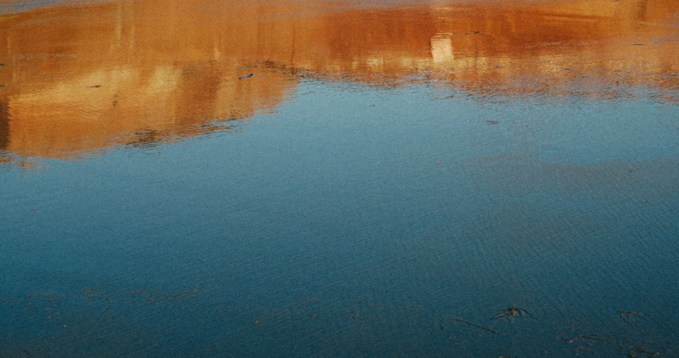 Ocean water reflecting red cliffs